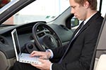 Mann mit Laptop im Auto